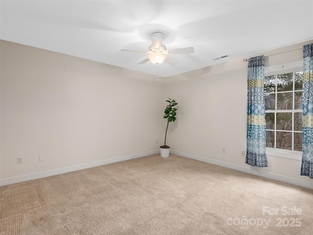 spare room with a ceiling fan, carpet, visible vents, and baseboards