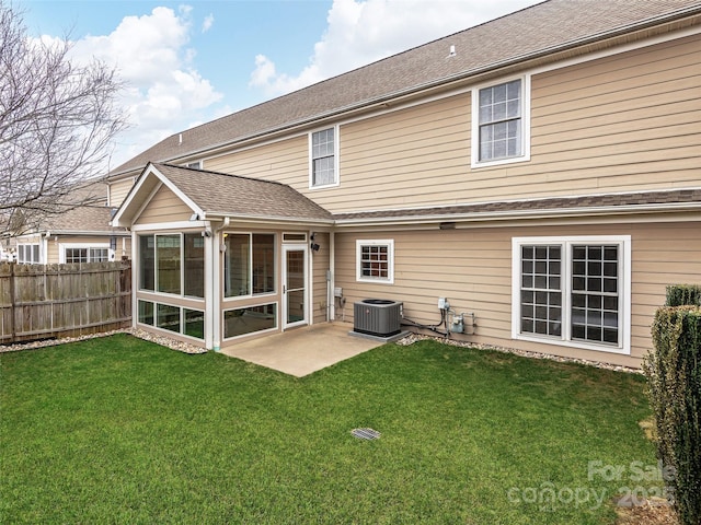 rear view of property with central air condition unit, a shingled roof, fence, a sunroom, and a yard