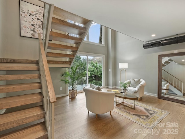 living room featuring stairway, wood finished floors, and baseboards