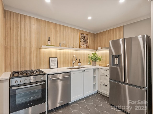 kitchen with dark tile patterned floors, light countertops, appliances with stainless steel finishes, white cabinetry, and a sink