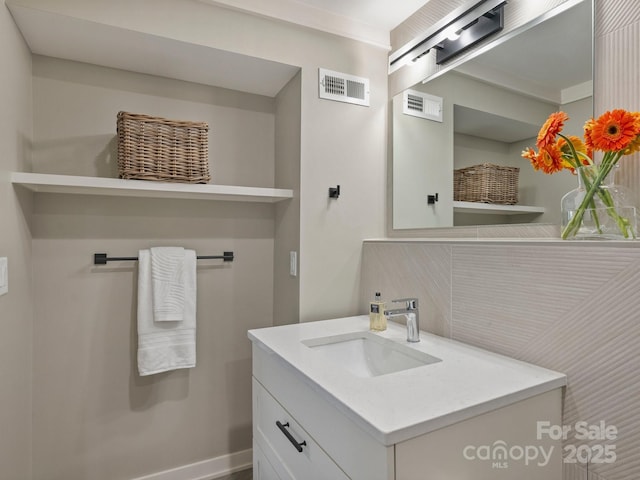 bathroom with visible vents, vanity, and baseboards