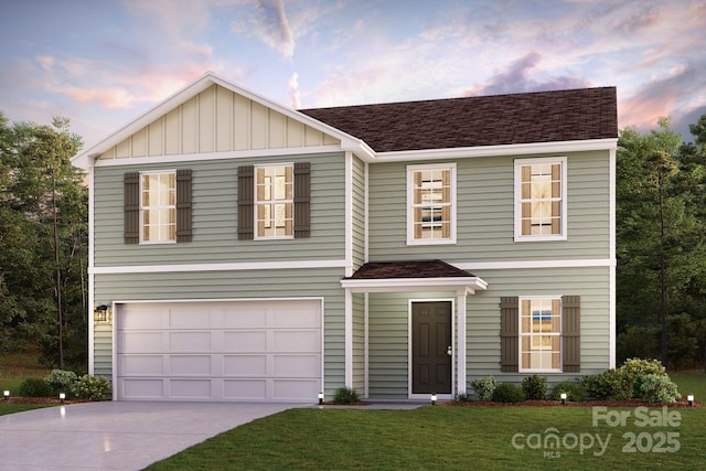 traditional home featuring concrete driveway, roof with shingles, an attached garage, a yard, and board and batten siding