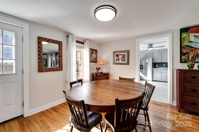 dining space featuring light wood-type flooring, ceiling fan, and baseboards