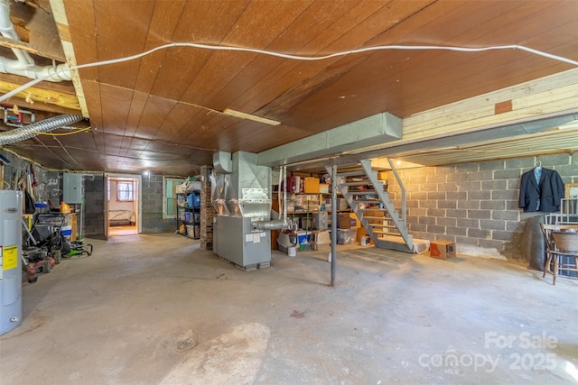 below grade area featuring concrete block wall, electric panel, wood ceiling, stairway, and heating unit