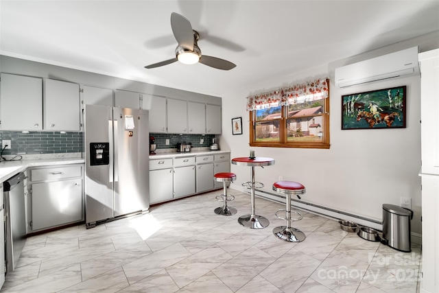 kitchen featuring marble finish floor, light countertops, decorative backsplash, appliances with stainless steel finishes, and an AC wall unit