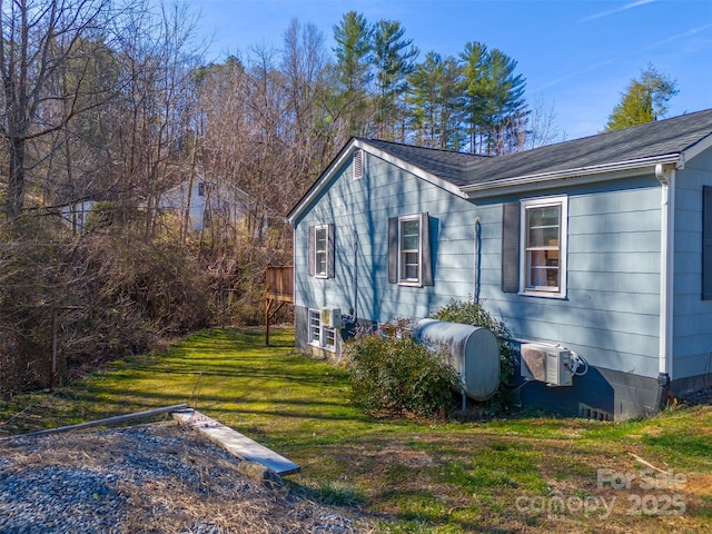 view of home's exterior featuring roof with shingles, a yard, and heating fuel