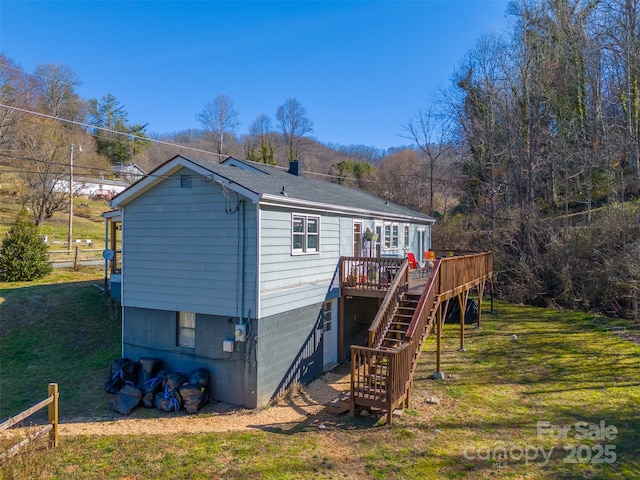 back of house with a lawn, a wooden deck, and stairs