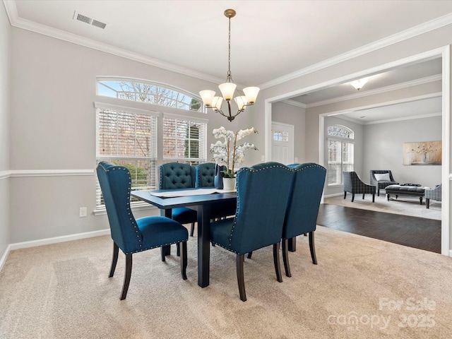 dining area with carpet floors, crown molding, visible vents, a chandelier, and baseboards