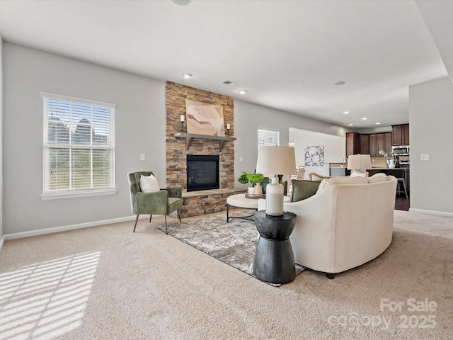 living area featuring a stone fireplace, recessed lighting, light carpet, visible vents, and baseboards