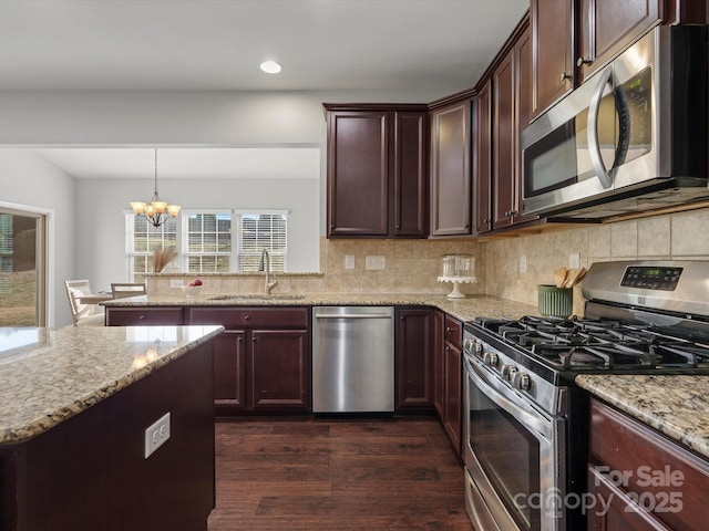 kitchen featuring backsplash, appliances with stainless steel finishes, dark wood-type flooring, and a sink