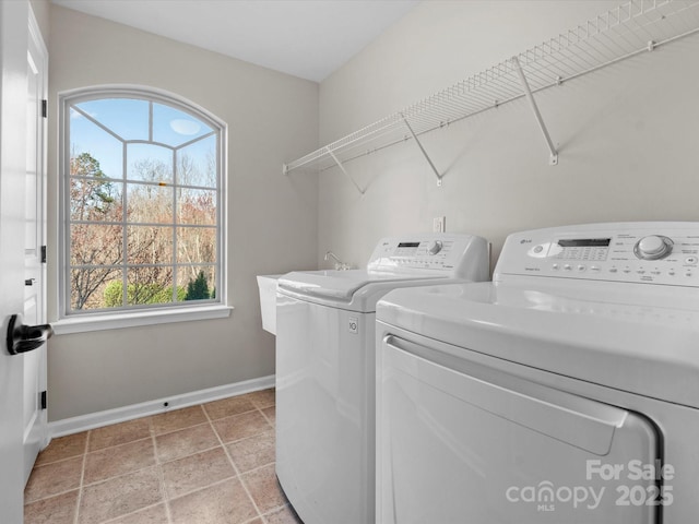 washroom with laundry area, baseboards, and washer and dryer