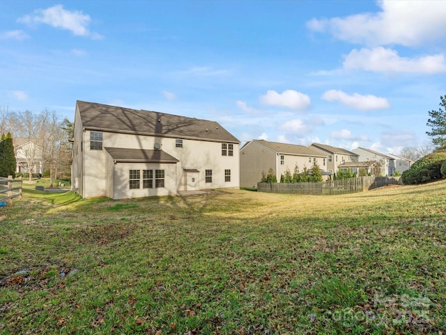 back of property featuring a yard, a residential view, and fence