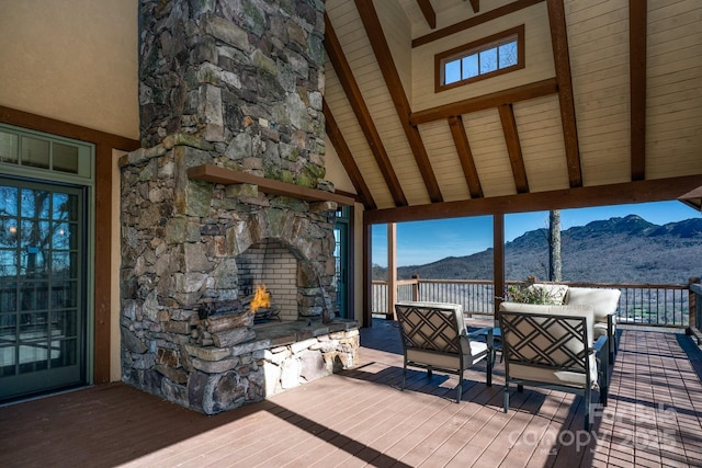 wooden deck with an outdoor living space with a fireplace and a mountain view