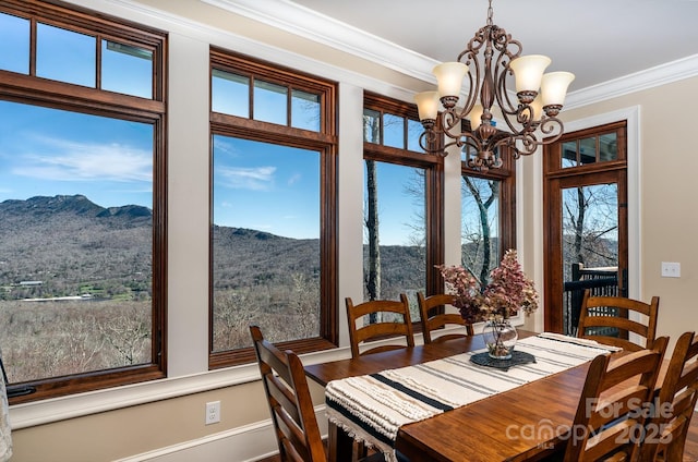 dining space featuring ornamental molding, wood finished floors, a mountain view, and an inviting chandelier