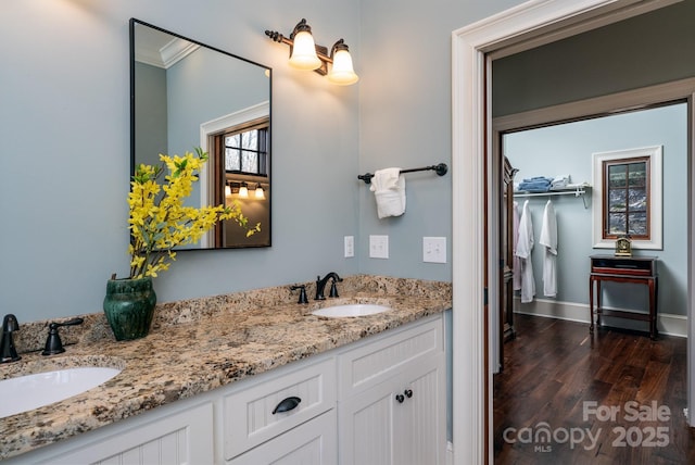 bathroom with double vanity, wood finished floors, and a sink