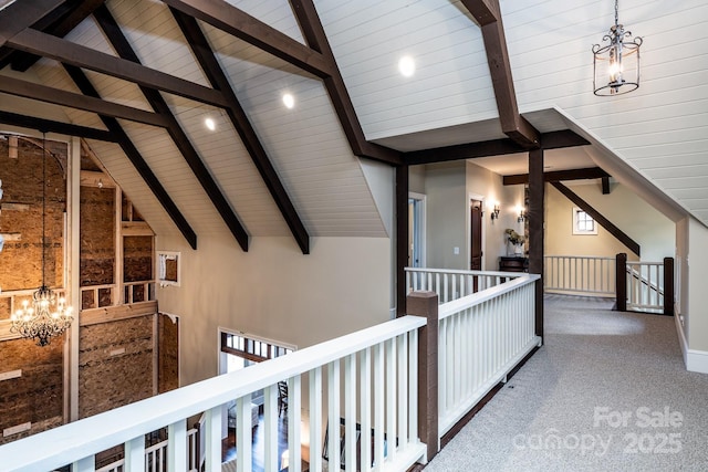 hall with carpet floors, high vaulted ceiling, beam ceiling, and an upstairs landing