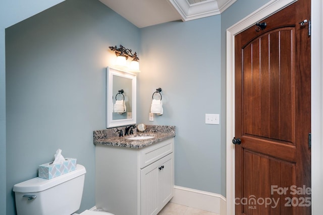 bathroom with toilet, ornamental molding, vanity, baseboards, and tile patterned floors