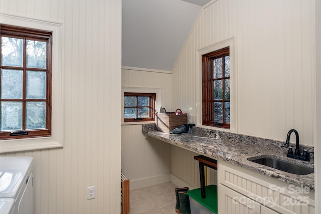 interior space featuring laundry area, separate washer and dryer, light tile patterned flooring, and a sink