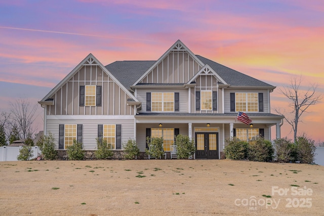 view of front of property with french doors, board and batten siding, and fence