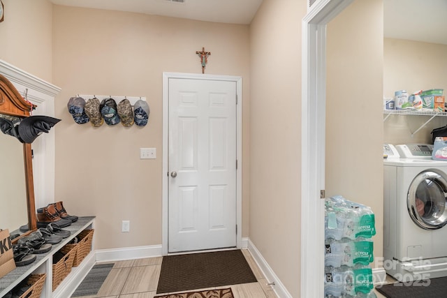 mudroom featuring washer and dryer and baseboards