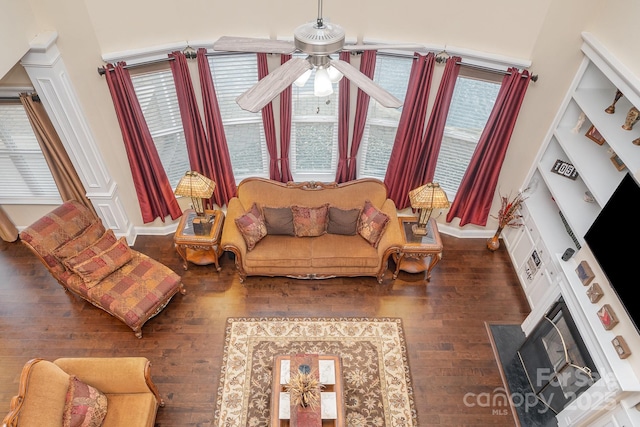 living area with hardwood / wood-style flooring, a fireplace with flush hearth, and a ceiling fan