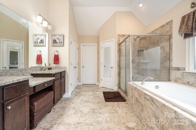 bathroom featuring lofted ceiling, a garden tub, vanity, and a shower stall