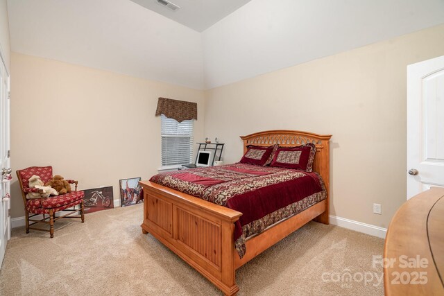 bedroom featuring visible vents, baseboards, light colored carpet, and vaulted ceiling