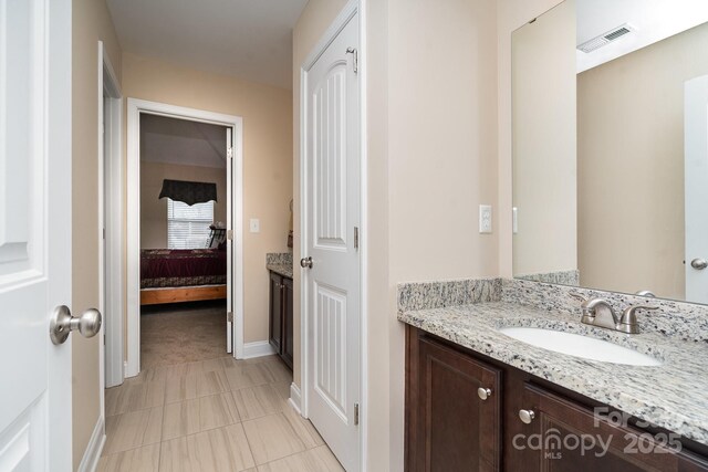 bathroom featuring visible vents, vanity, ensuite bathroom, and baseboards