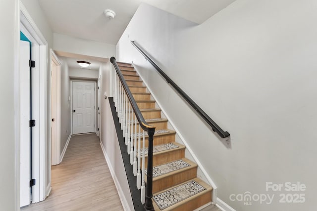 stairway featuring baseboards and wood finished floors