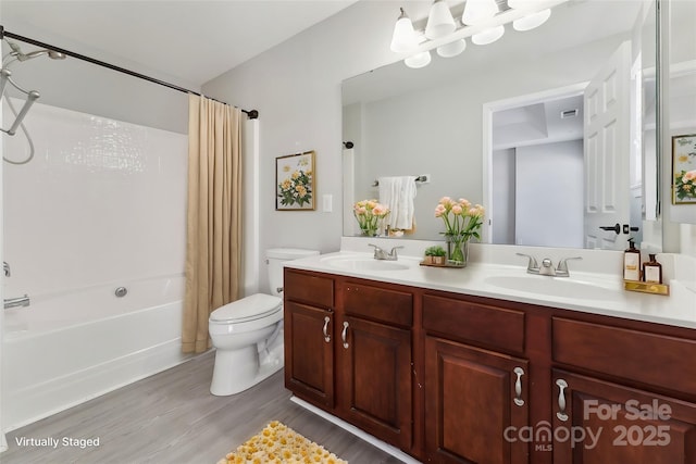 full bath featuring toilet, double vanity, shower / bath combo with shower curtain, and a sink