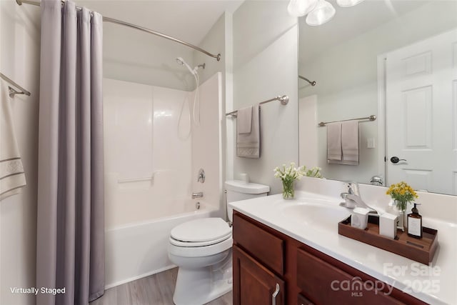 full bathroom with toilet, shower / bathtub combination with curtain, wood finished floors, and vanity