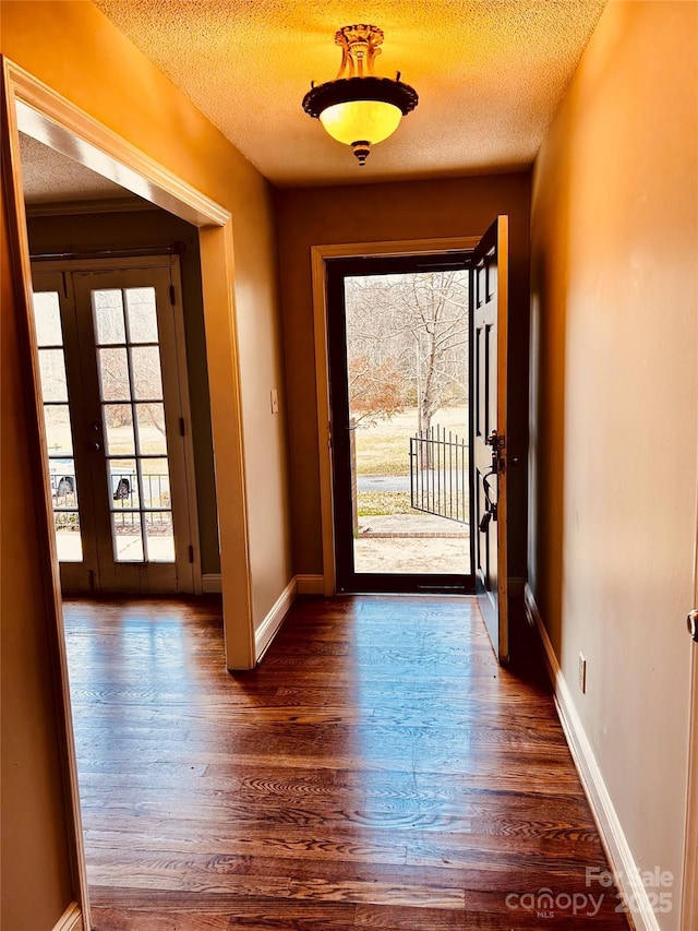 entryway featuring a textured ceiling, french doors, and dark wood-style flooring