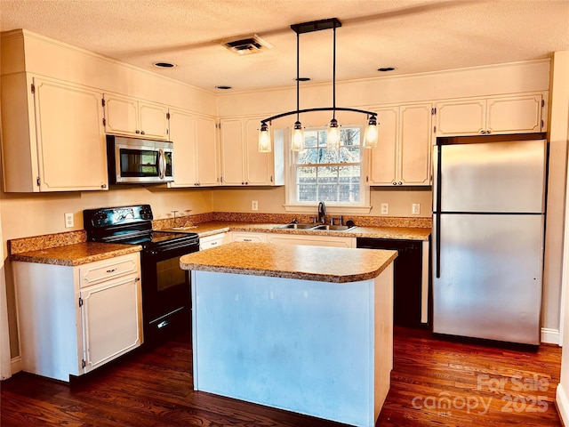 kitchen featuring visible vents, dark wood-type flooring, black appliances, white cabinetry, and a sink