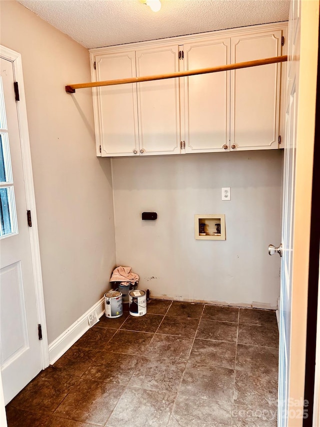 clothes washing area with hookup for a washing machine, a textured ceiling, cabinet space, and hookup for an electric dryer