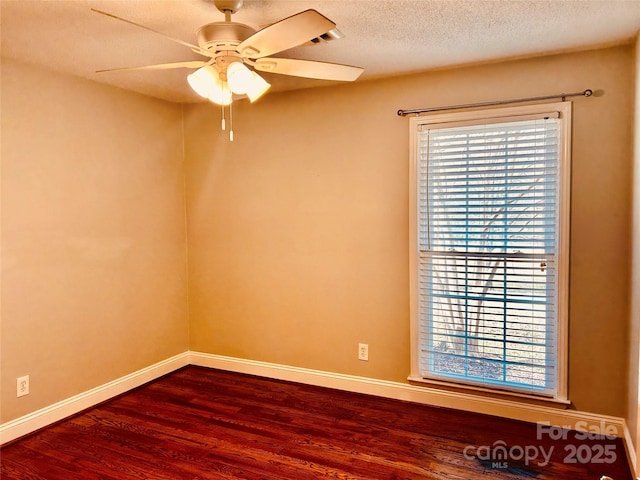 unfurnished room featuring dark wood-style floors, a textured ceiling, baseboards, and a ceiling fan