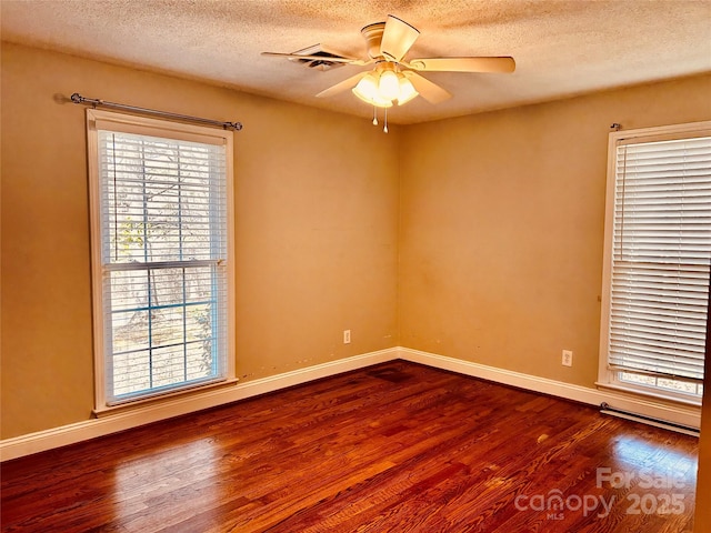 unfurnished room featuring ceiling fan, baseboards, and dark wood-type flooring