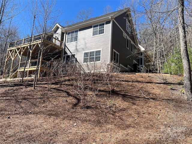 rear view of property featuring a wooden deck