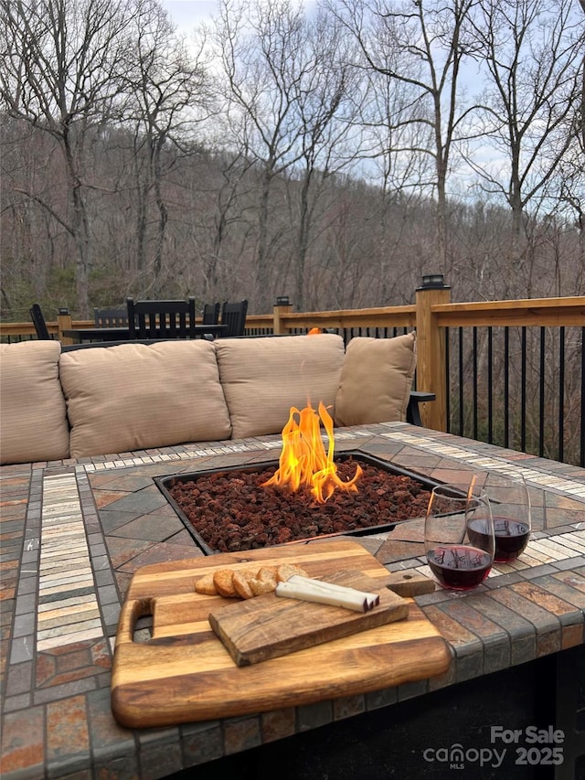 exterior space featuring a view of trees and an outdoor fire pit