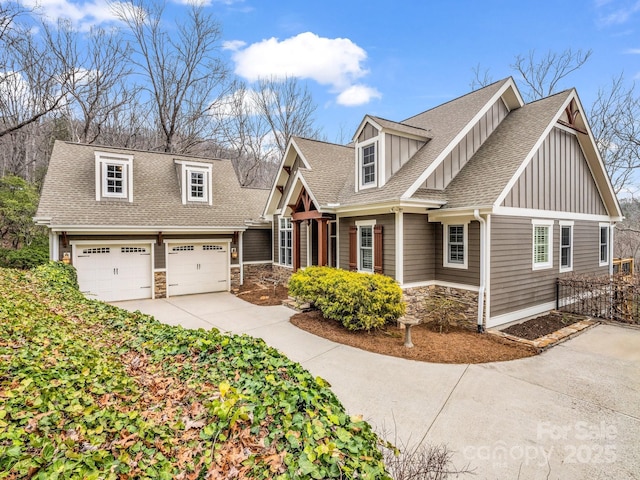 craftsman house featuring board and batten siding, concrete driveway, roof with shingles, a garage, and stone siding