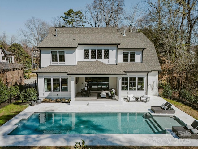 back of house with a fenced in pool, fence, a shingled roof, a patio area, and an outdoor hangout area