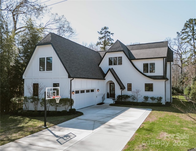 view of front of house featuring board and batten siding, concrete driveway, a front yard, roof with shingles, and a garage