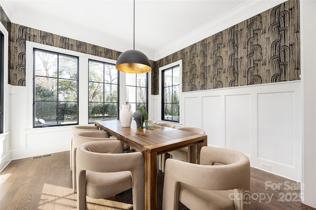 dining space with a decorative wall, plenty of natural light, and crown molding