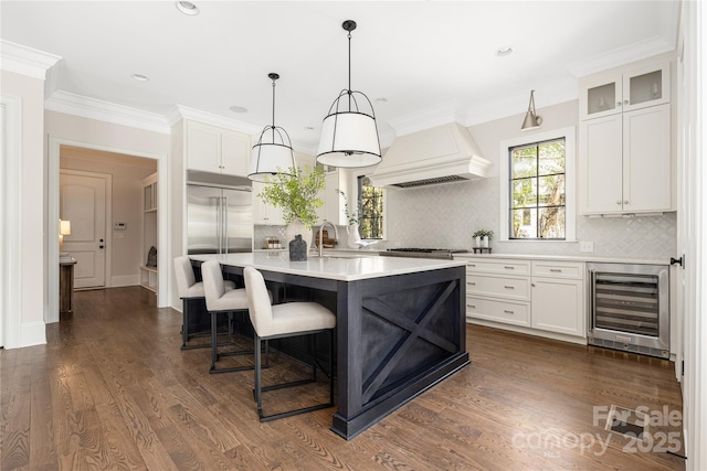 kitchen featuring beverage cooler, custom range hood, a sink, light countertops, and dark wood-style flooring