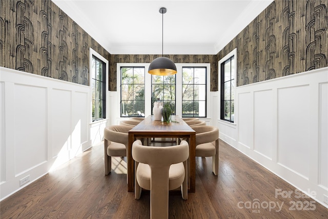 dining space with a decorative wall, wallpapered walls, crown molding, and a wainscoted wall