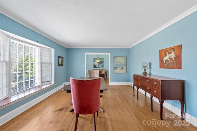 dining room with light wood-type flooring, baseboards, and ornamental molding