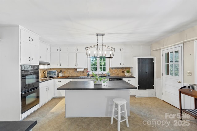 kitchen featuring dark countertops, white cabinets, and a kitchen island