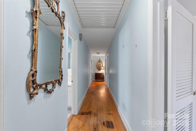 hall with light wood finished floors and baseboards