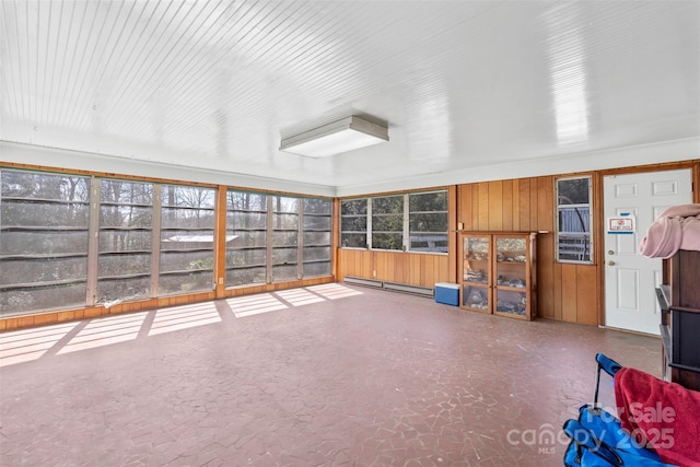 unfurnished sunroom featuring a wealth of natural light and a baseboard radiator