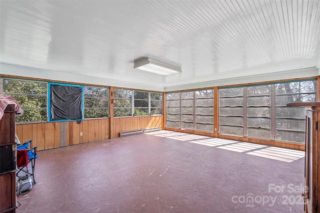 unfurnished sunroom featuring a healthy amount of sunlight and a baseboard radiator