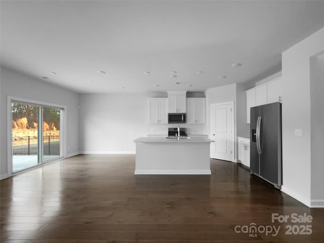 kitchen with a kitchen island with sink, dark wood-type flooring, white cabinets, open floor plan, and appliances with stainless steel finishes